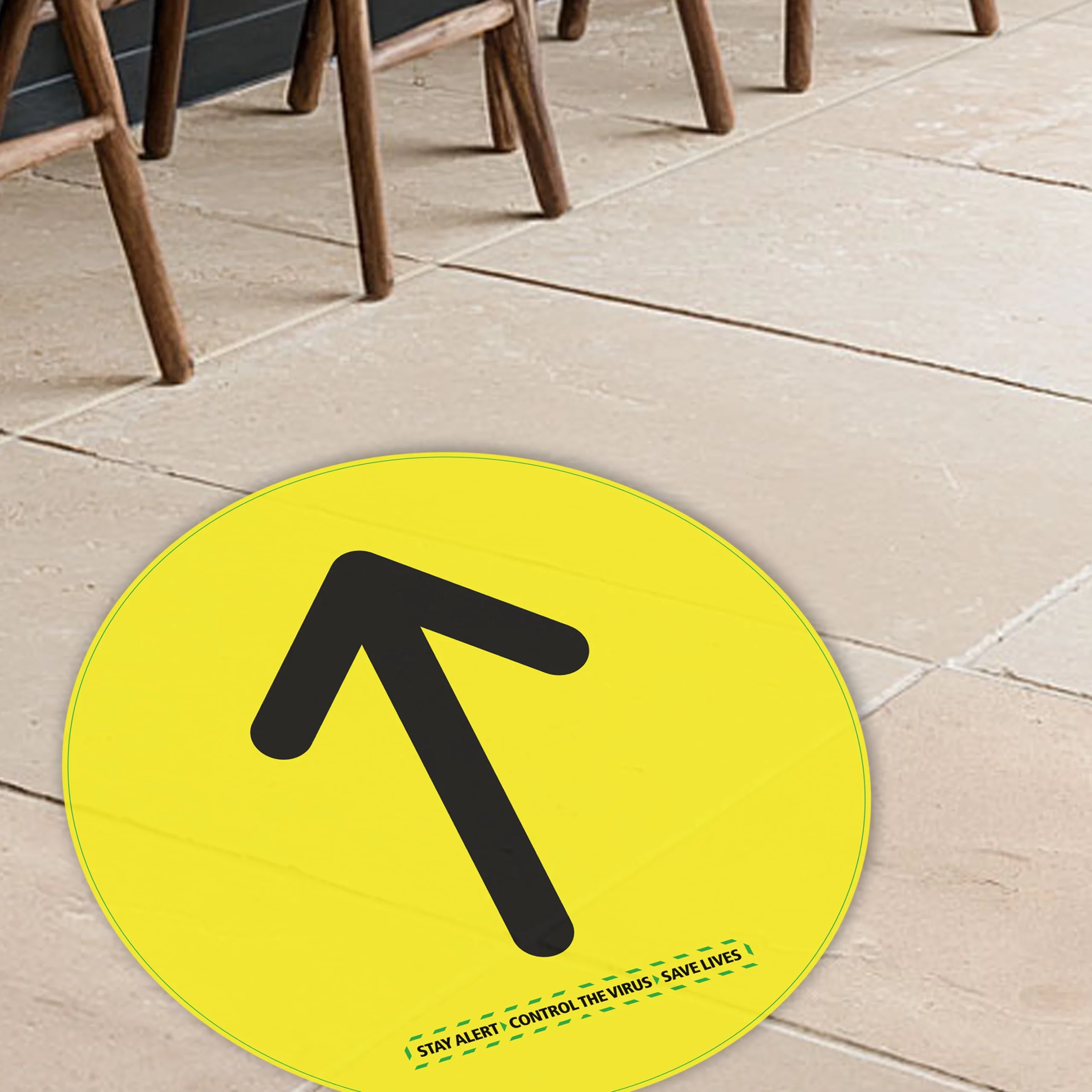 Yellow circular floor arrow graphic on indoor stone tiles printed on high-tack vinyl with R12 slip-rated laminate