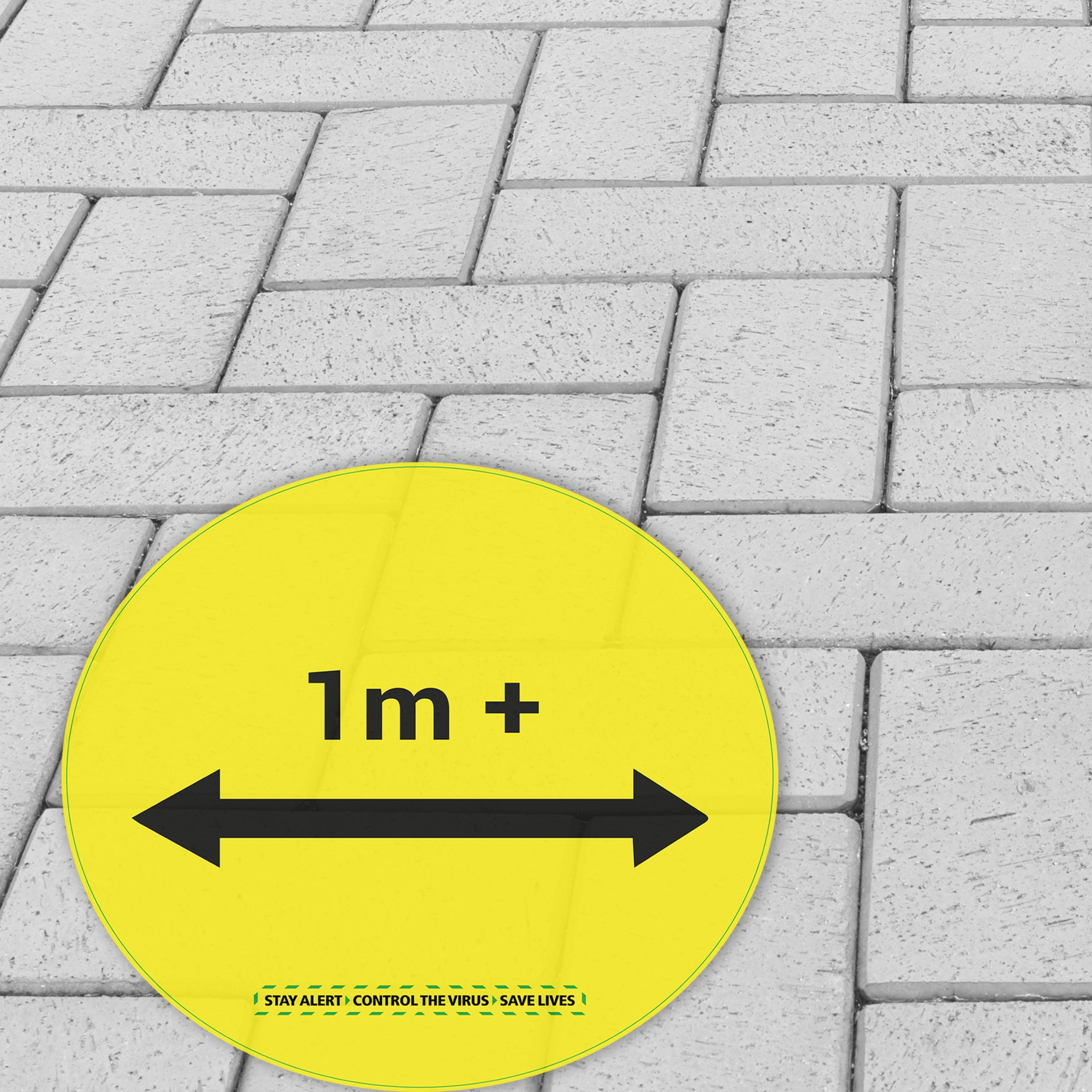 Outdoor Floor Graphic (for flat surfaces)- 114 | Yellow circular floor sticker with “1m+” distancing message applied to outdoor block paving surface printed on R9 anti-slip vinyl