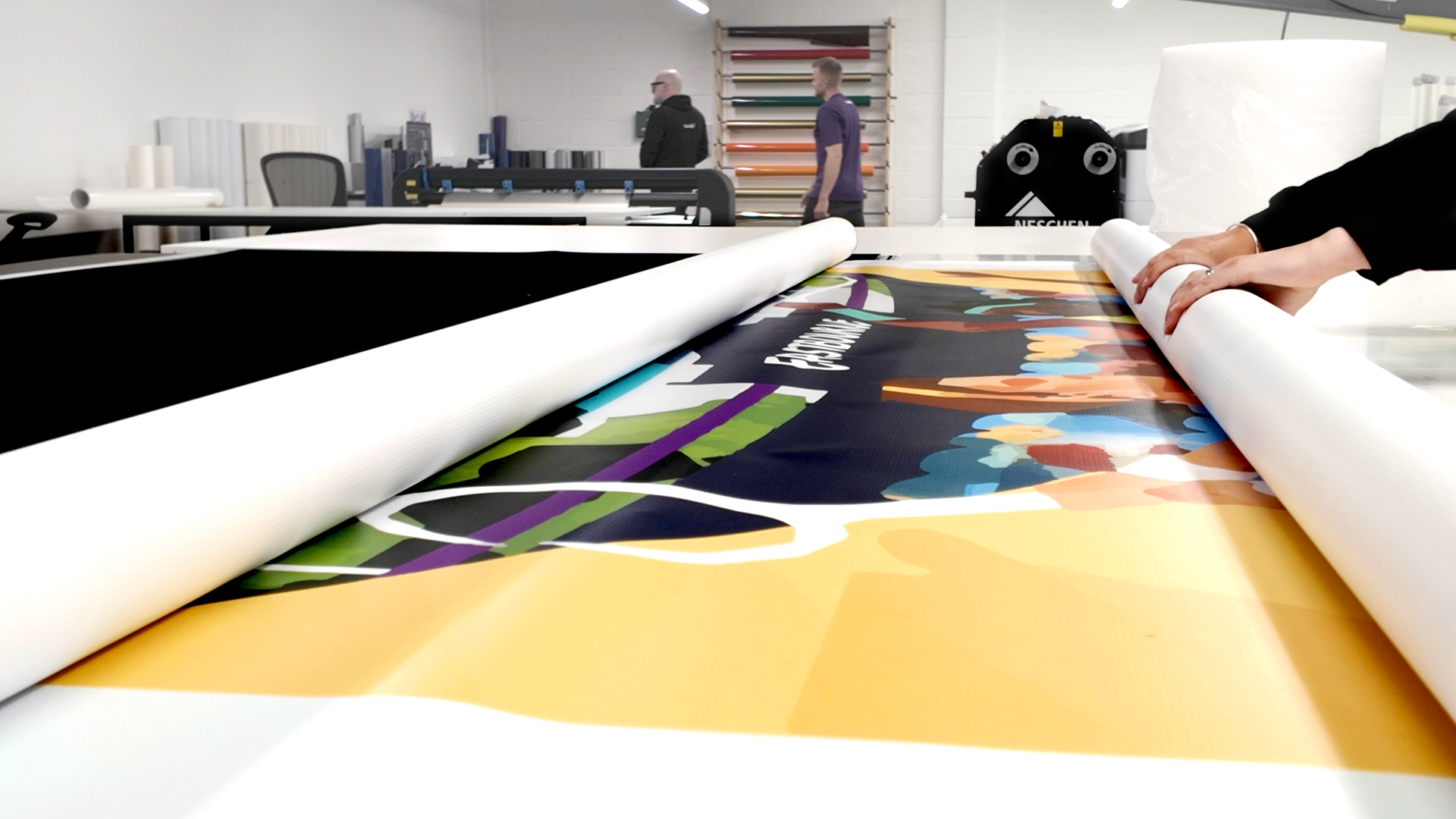A large LTA Tennis poster being carefully rolled up at Beautiful LFP’s production studio for installation at the Eastbourne Tennis Tournament.