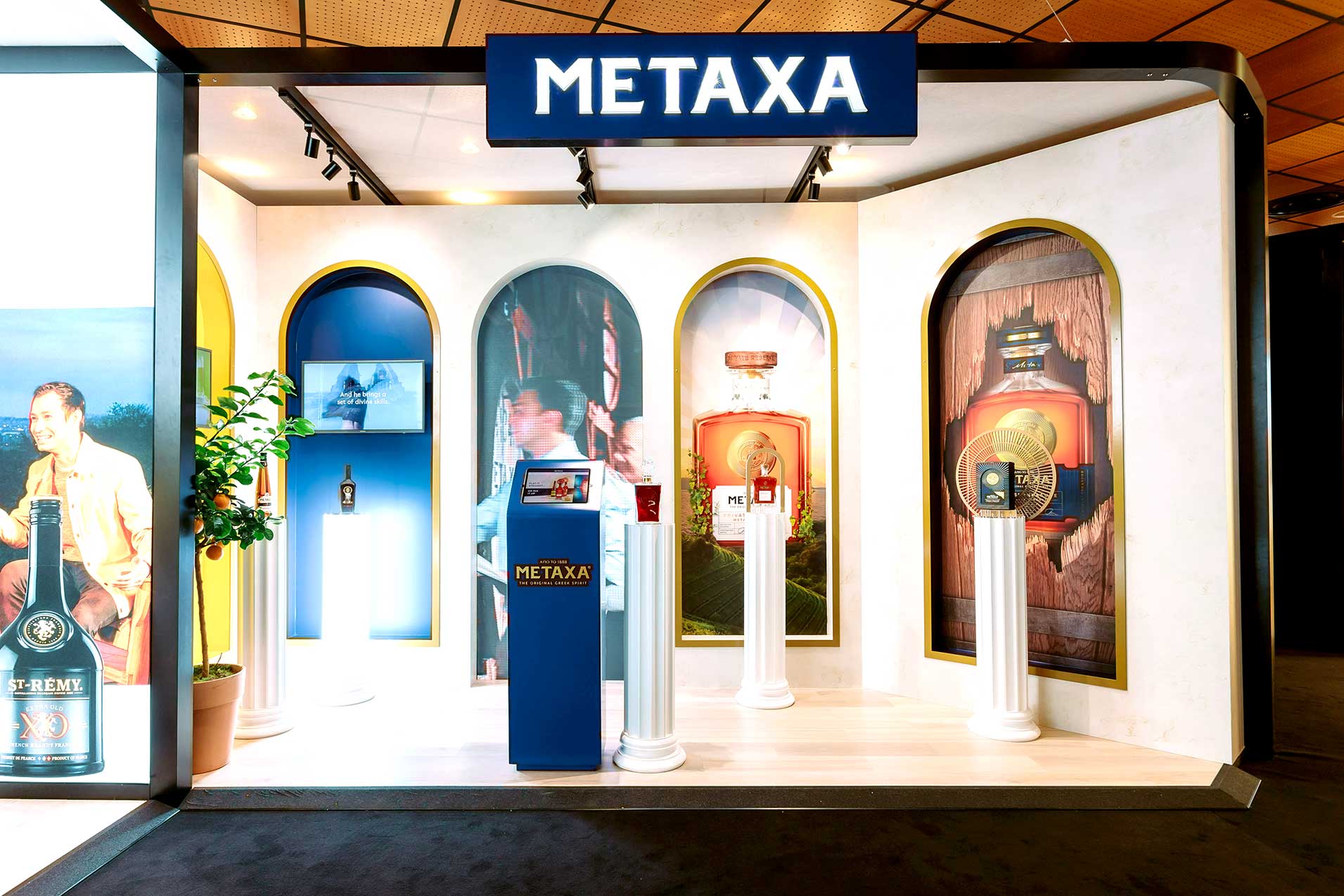 Metaxa exhibition stand with illuminated signage, branded plinths, and large-format printed graphics by Beautiful LFP for Rémy Cointreau.