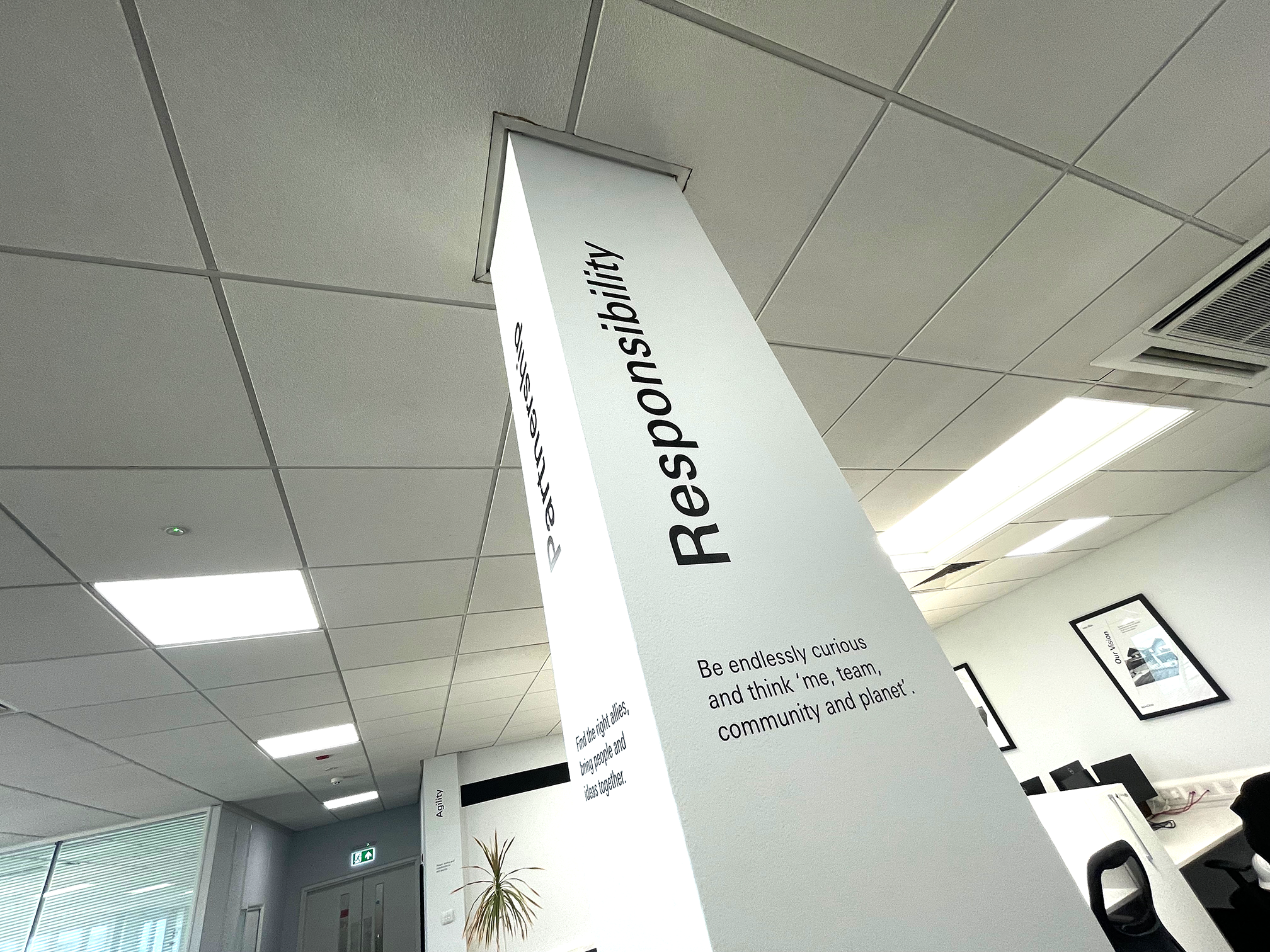 Schüco UK office column signage installation in Milton Keynes featuring branded corporate values graphic